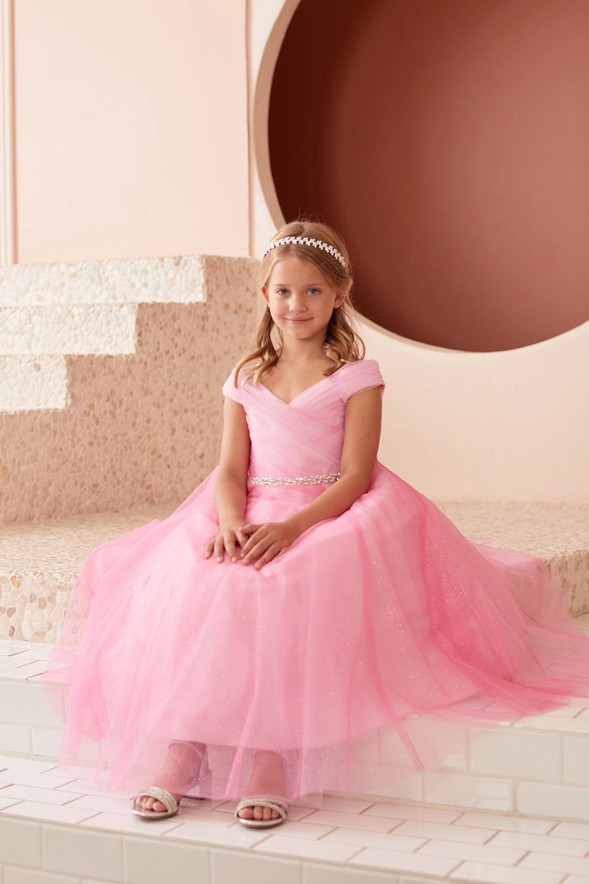 The Hot Pink kids pageant dress has an asymmetrically pleated neckline.