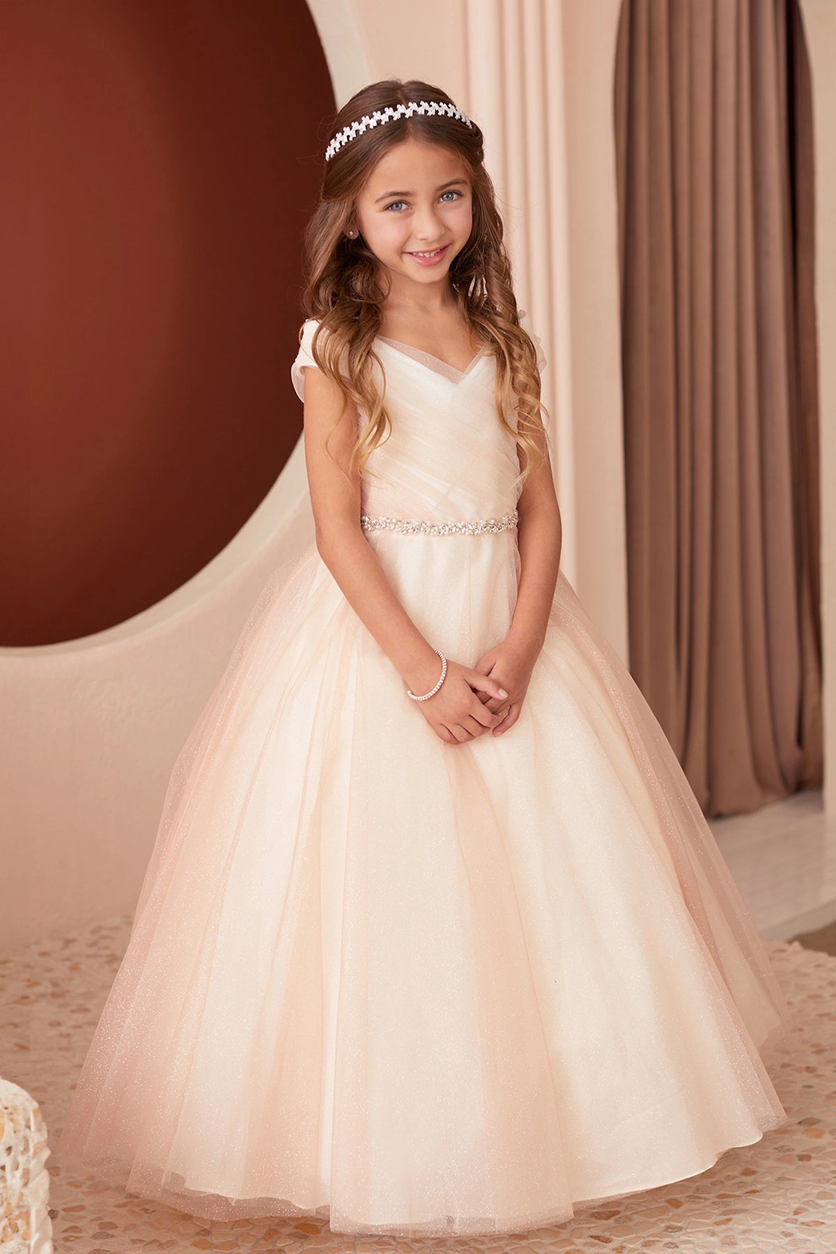 The Rose Gold kids pageant dress has an asymmetrically pleated neckline.