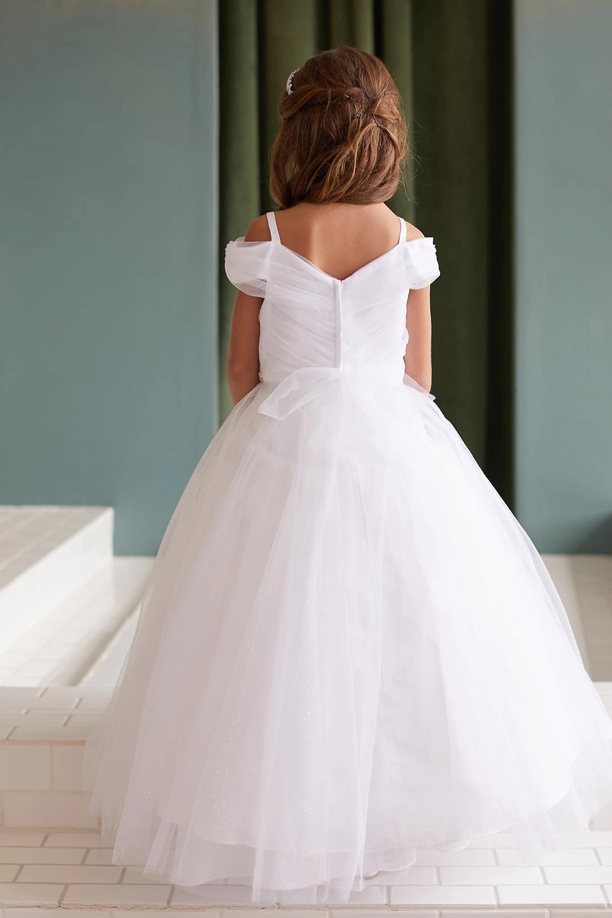 The White kids pageant dress has a tied sash across the back waist.