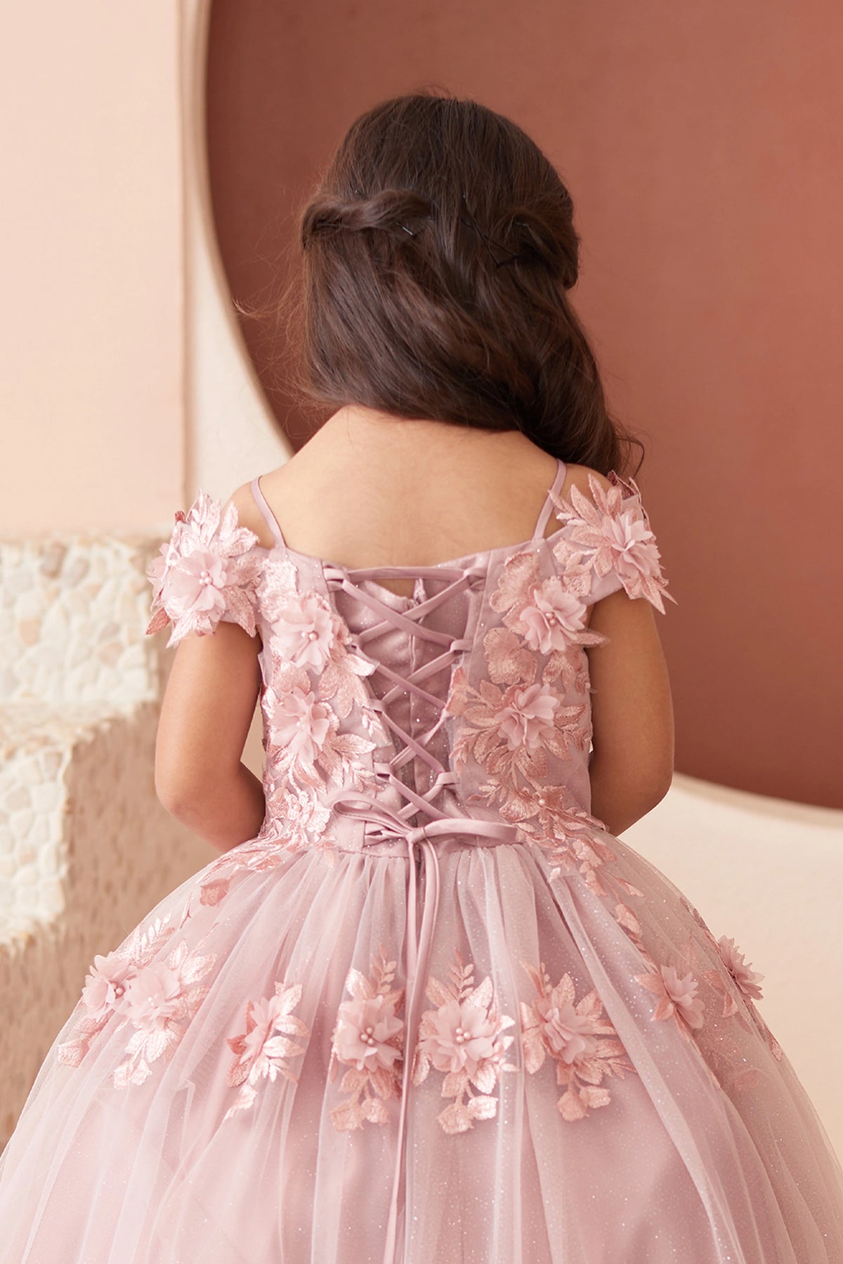Seen from up close, this Dusty Rose kids pageant dress displays lace trim across the upper back.