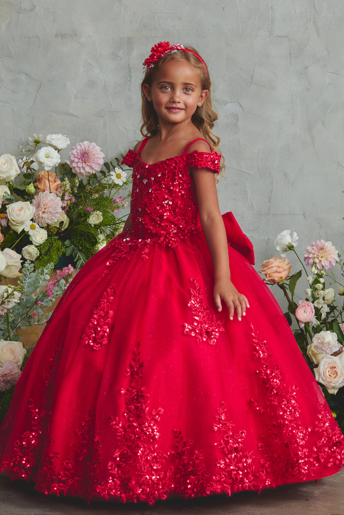 The Red kids pageant dress has lace appliques on a glitter tulle skirt.