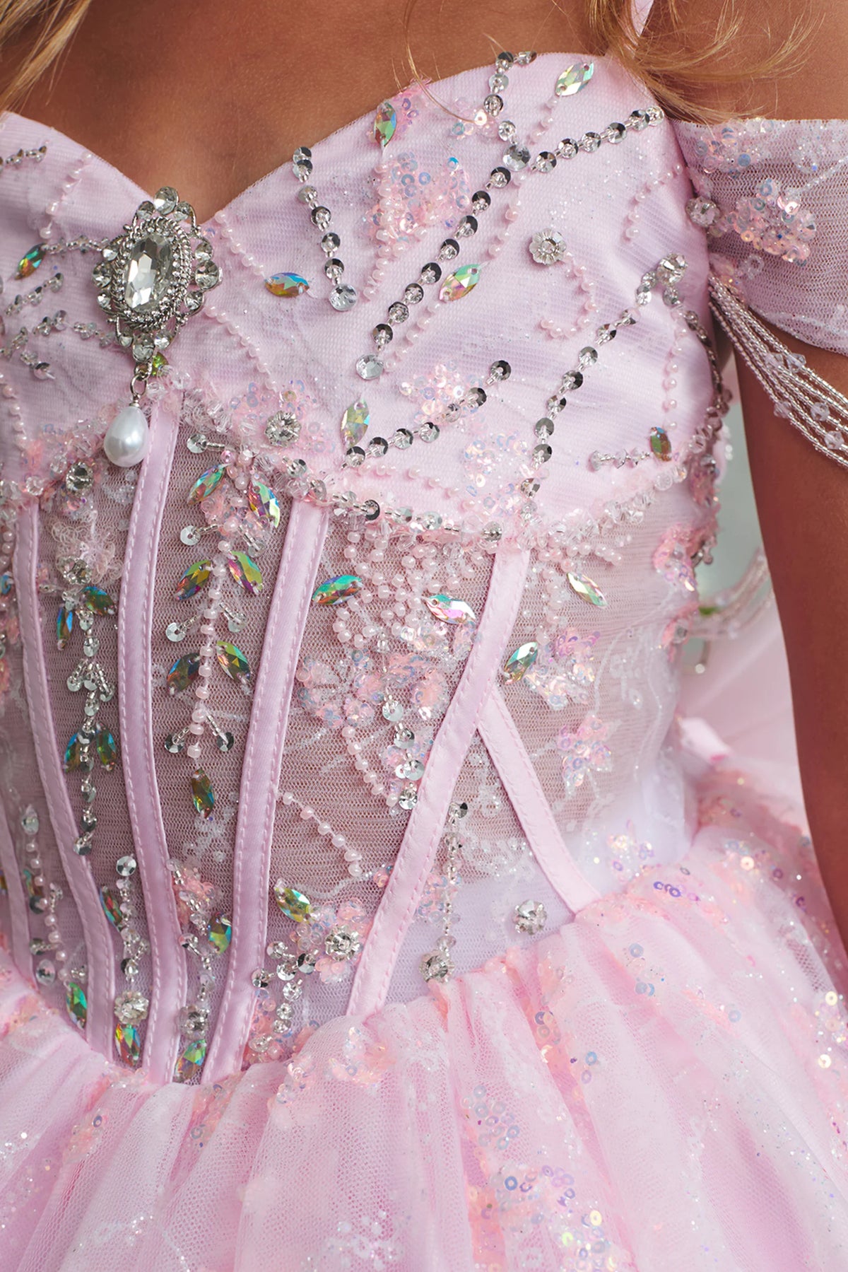 The Pink kids pageant dress has rhinestones over sheer bodice panels.