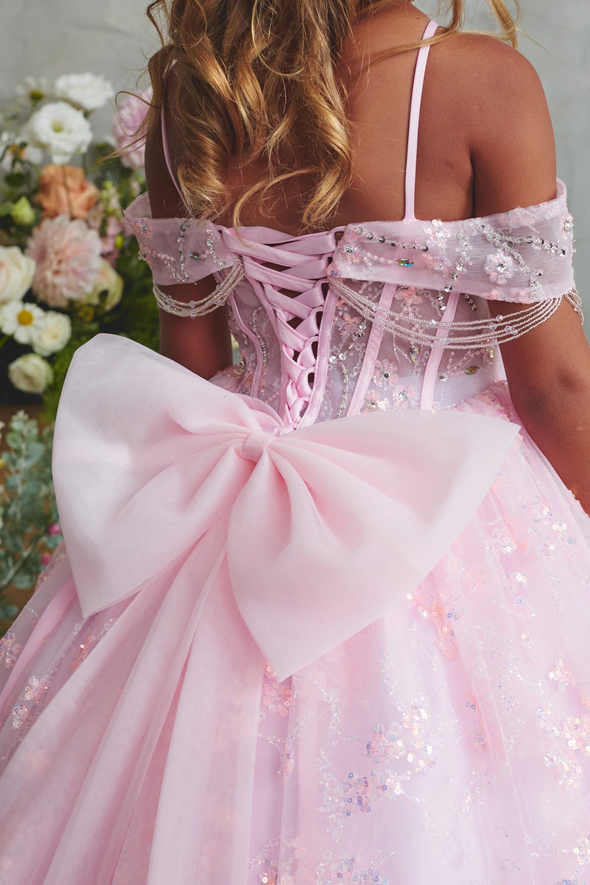 Seen from up close, this Pink kids pageant dress displays back lacing above a large bow.