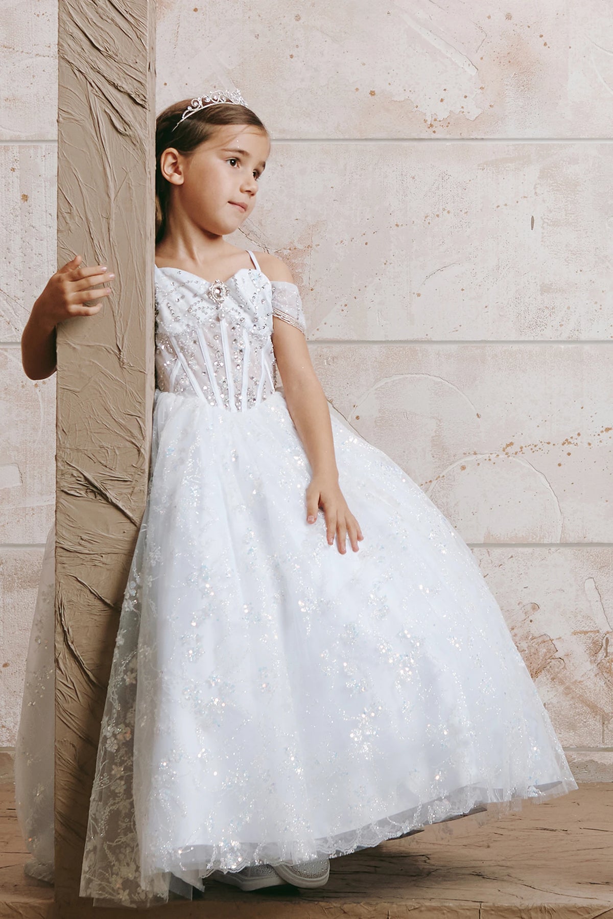 White kids pageant dress featuring beadwork over sheer bodice panels.