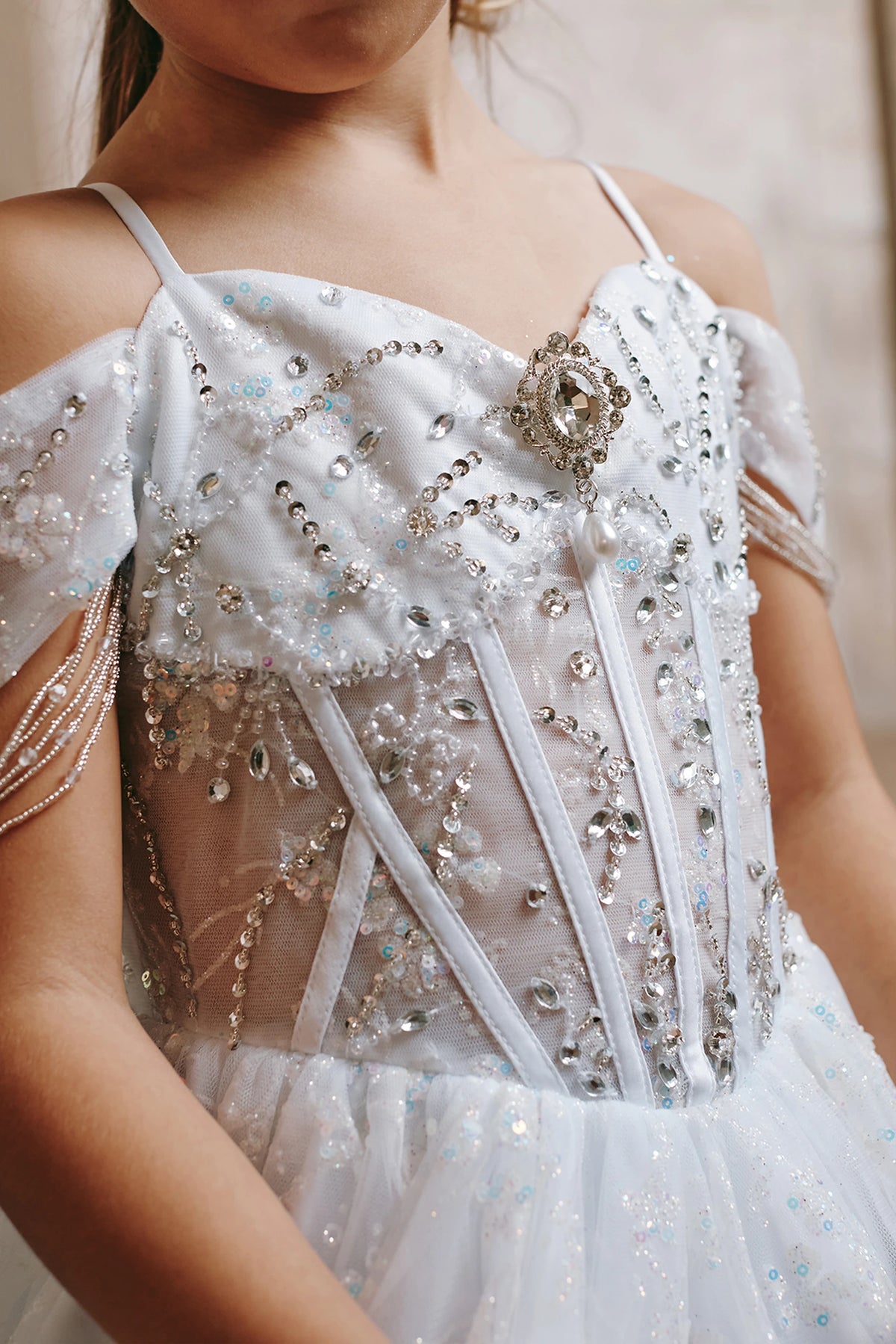 Visible details on the White kids pageant dress include beads and sequins over sheer bodice panels.
