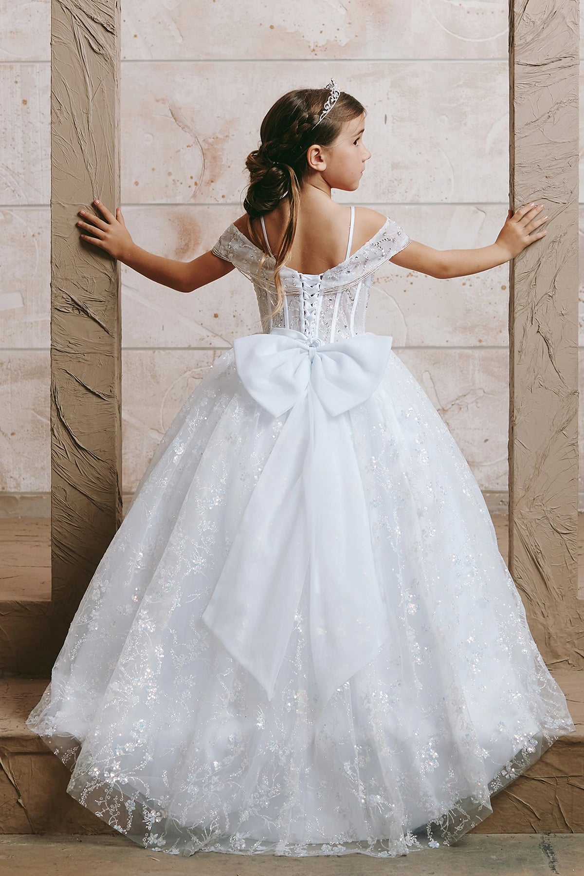 Seen from the front, this White kids pageant dress displays beadwork over sheer bodice panels.