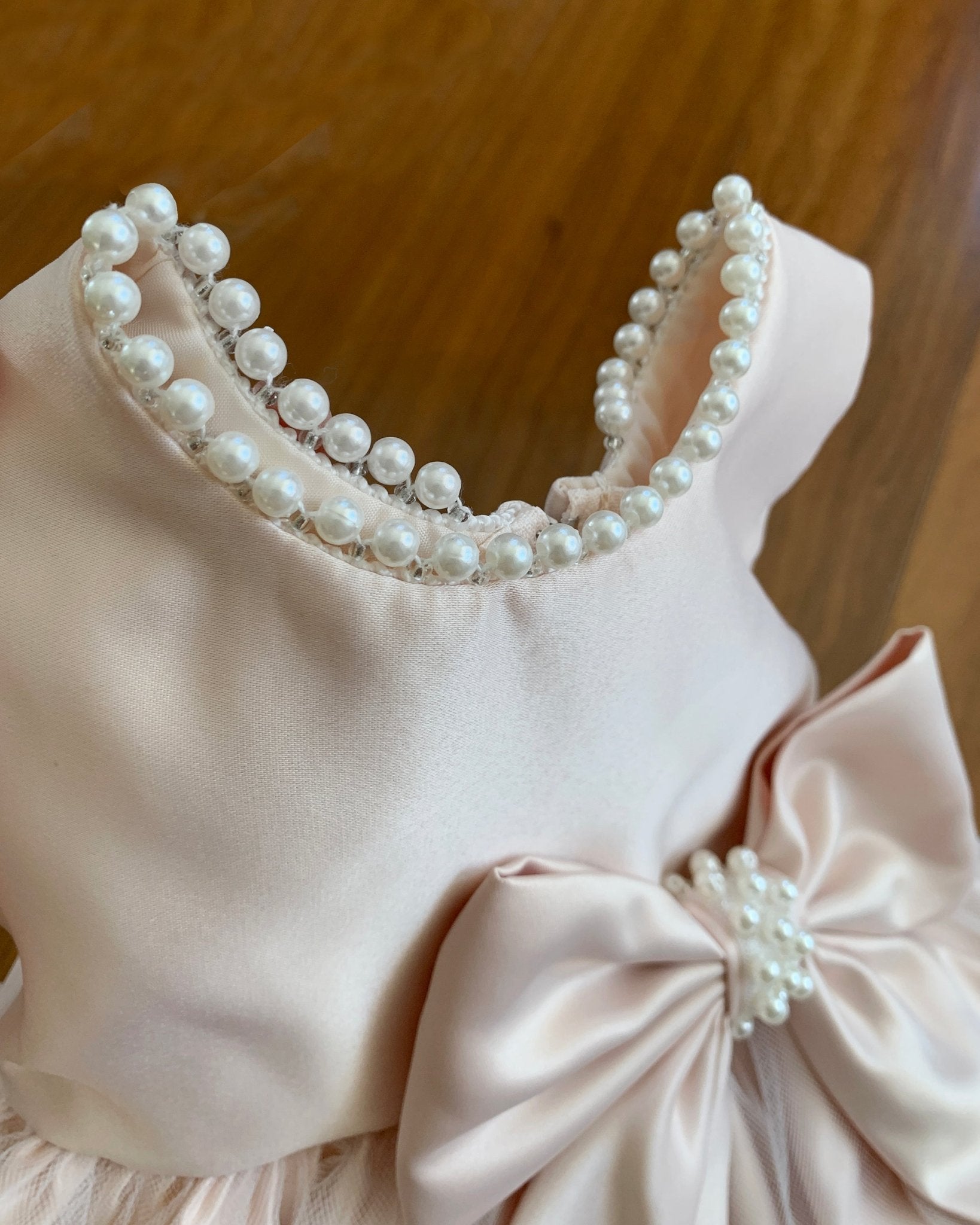 Pink flower girl dress with soft pearl embellishments around the neck part.