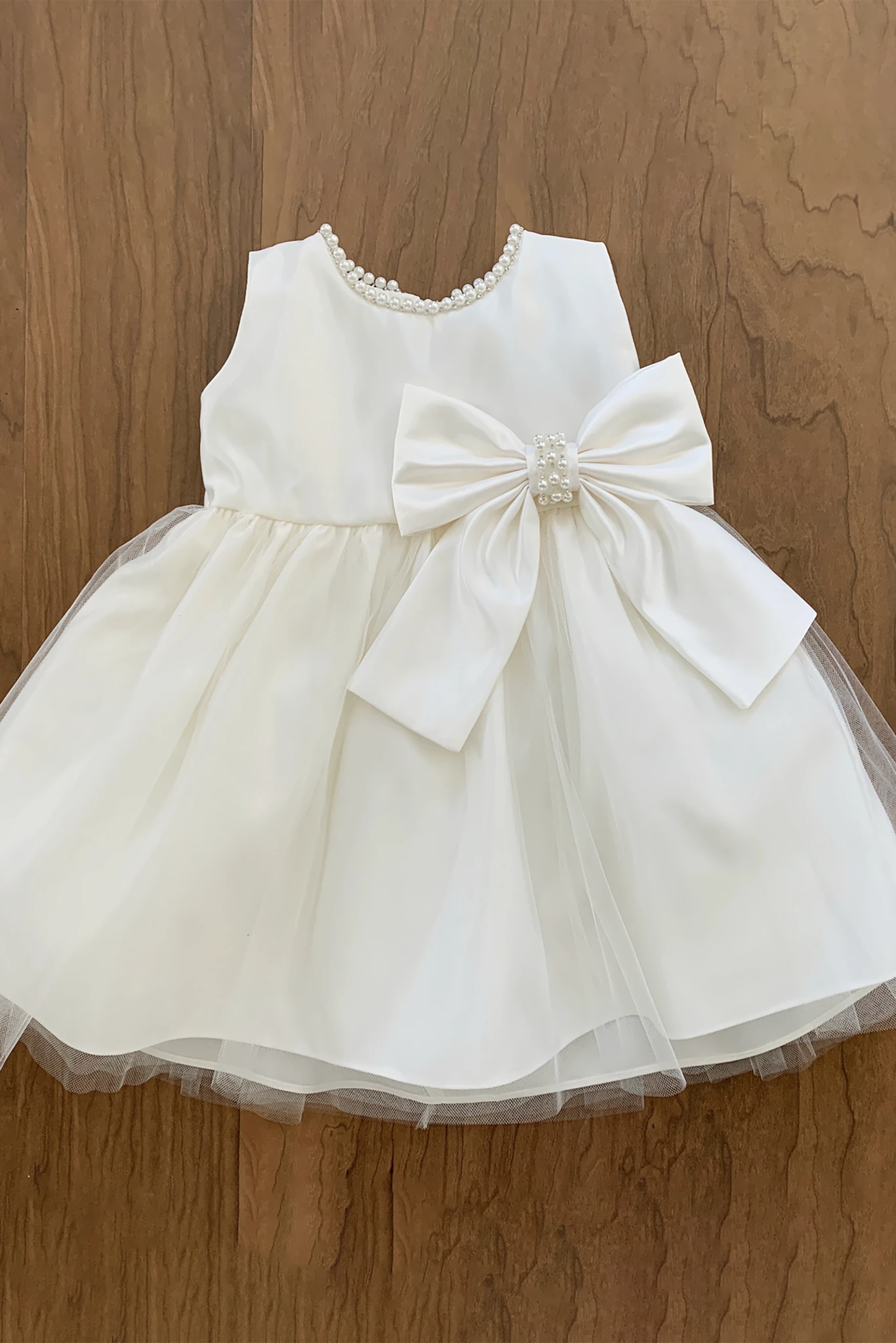 Ivory flower girl dress with a large bow.