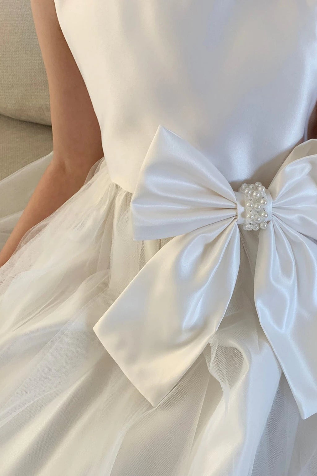 Ivory flower girl dress with a large bow detail.