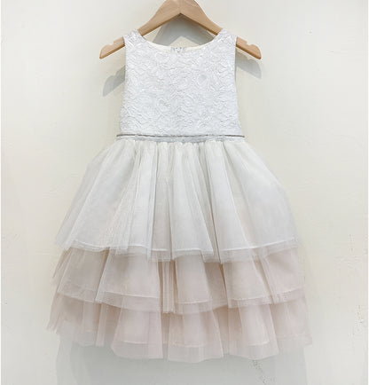 White lace dress with a layered tulle skirt on a hanger against a white background