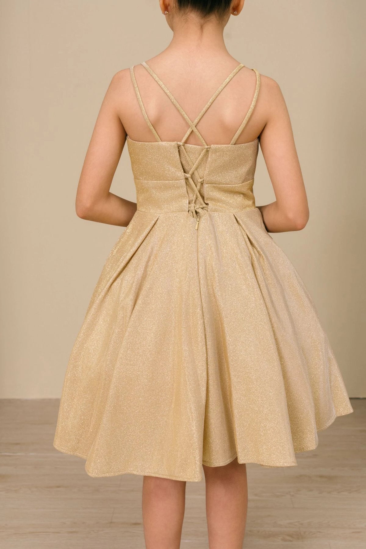 Finished details of back lacing and crossed straps distinguish the Gold kids party dress.