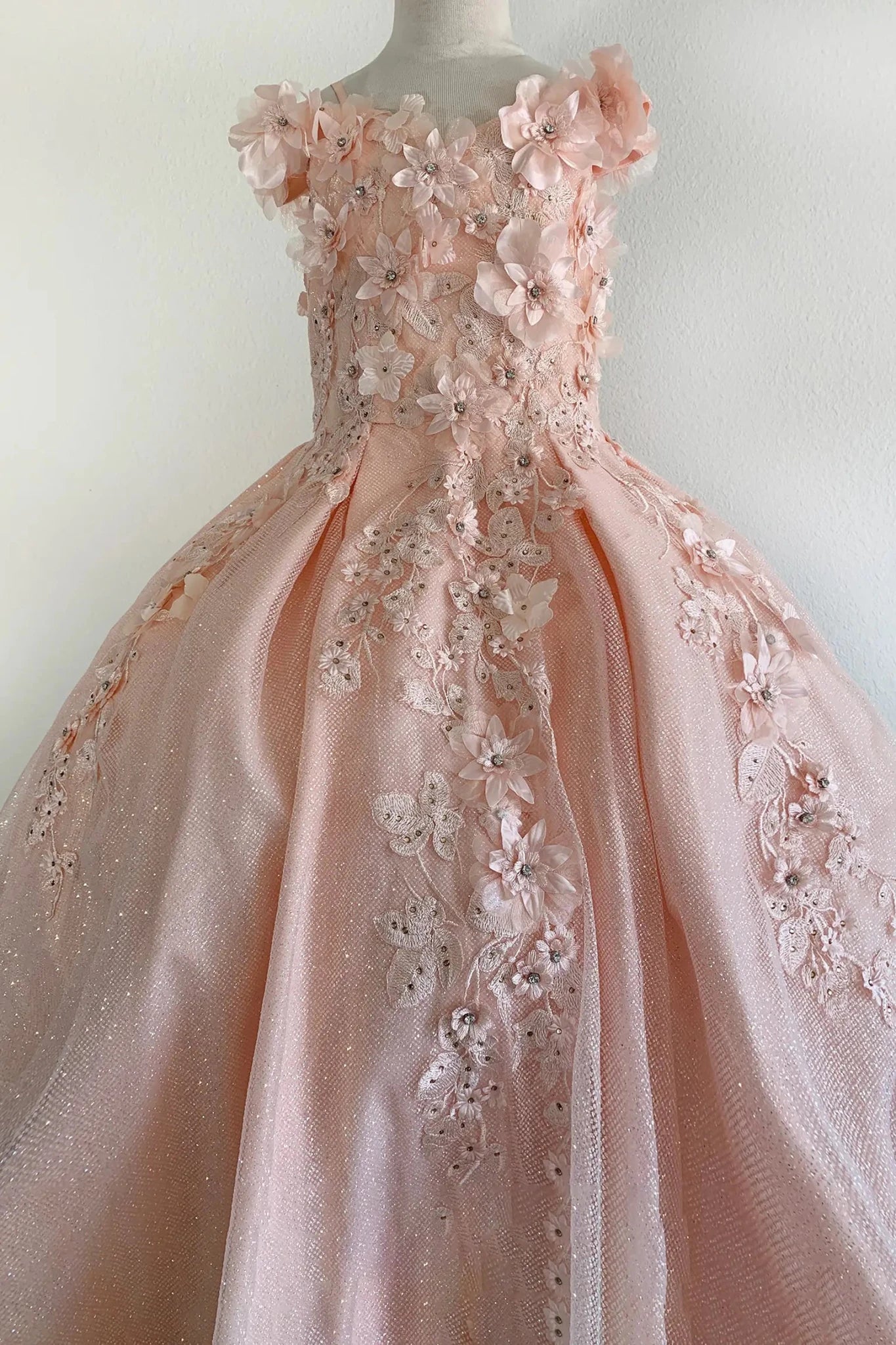Peach blush front view kids mini quinceañera mini quince dress with 3D stone and pearl embellishments, fitted bodice and layered skirt.