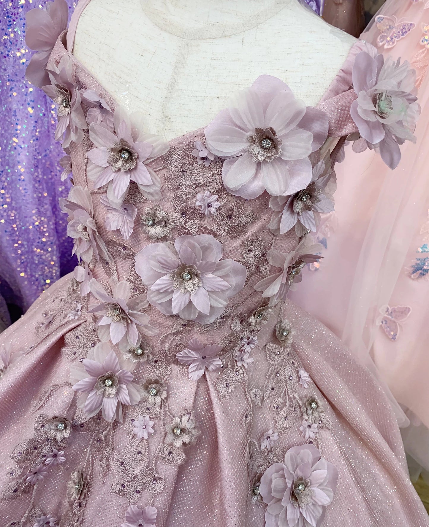 Dusty rose close-up kids mini quinceañera mini quince dress with floral lace, bead detailing and shimmering accents.