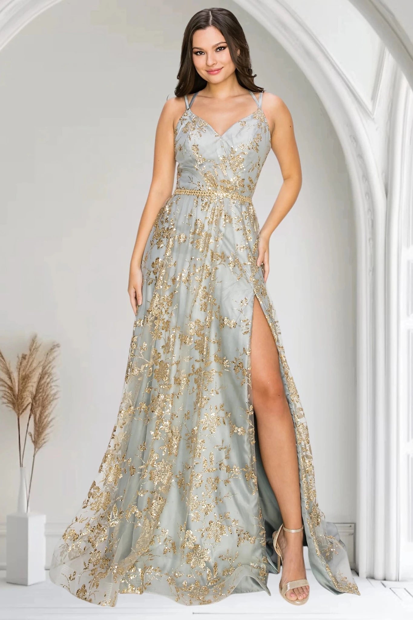 Silver evening gown with V-neckline framed by dual spaghetti straps