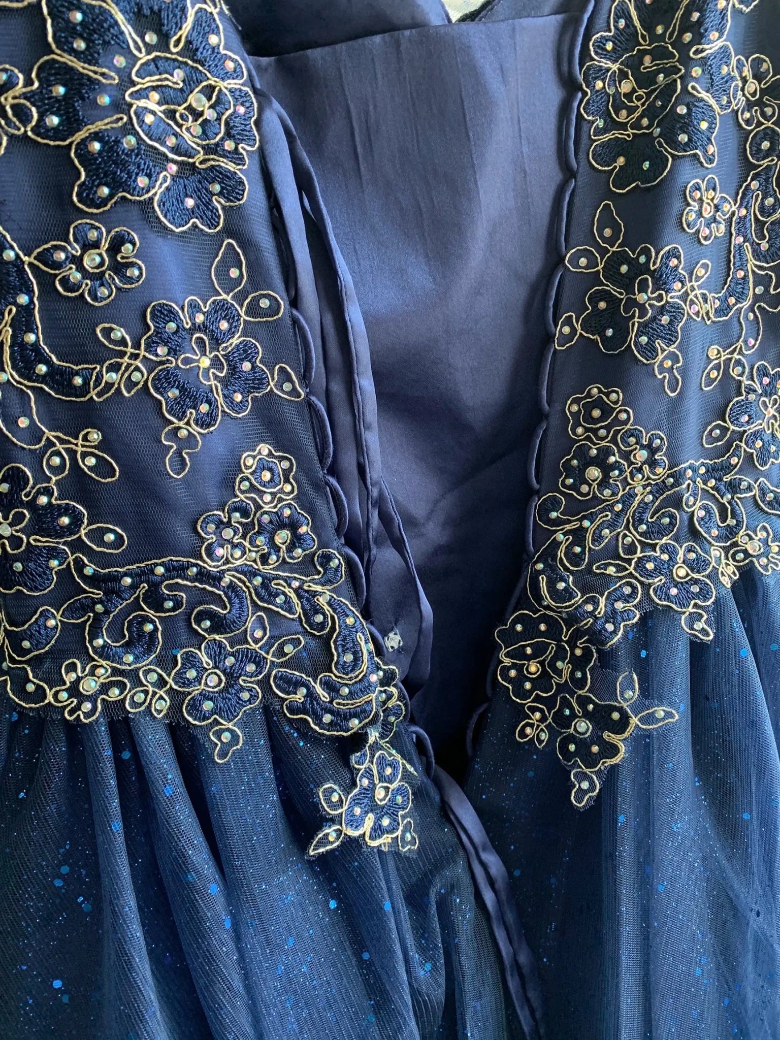 Close-up of blue mini quince dress with metallic glitter overlay shimmering tulle layers and sparkle accents
