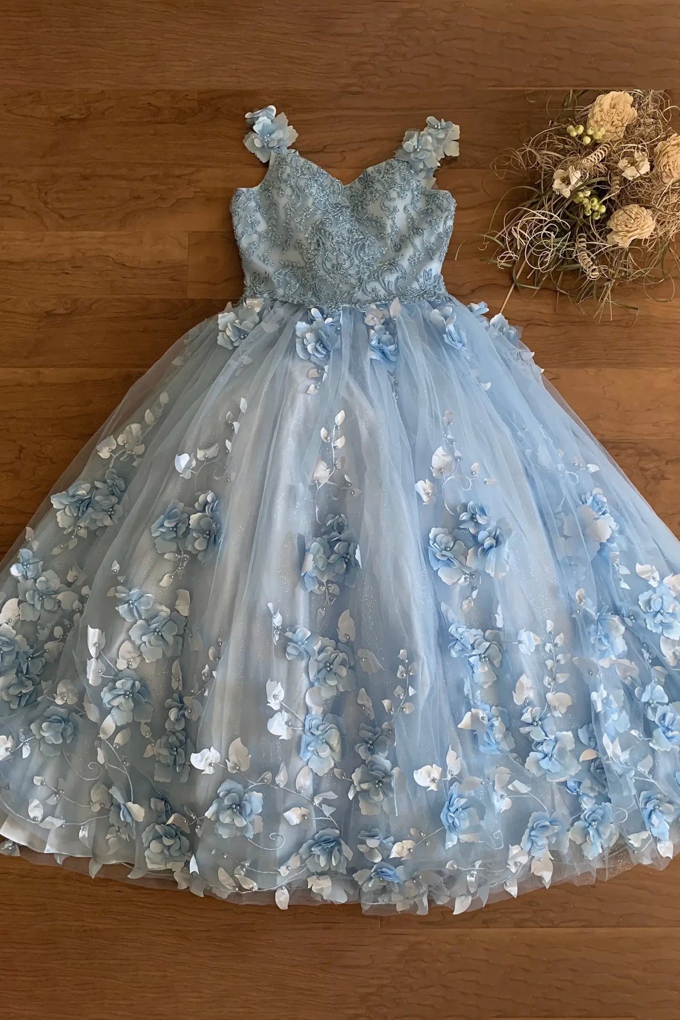 Close-up of blue mini quince dress with 3D floral embellishments stones pearls and intricate fabric detailing