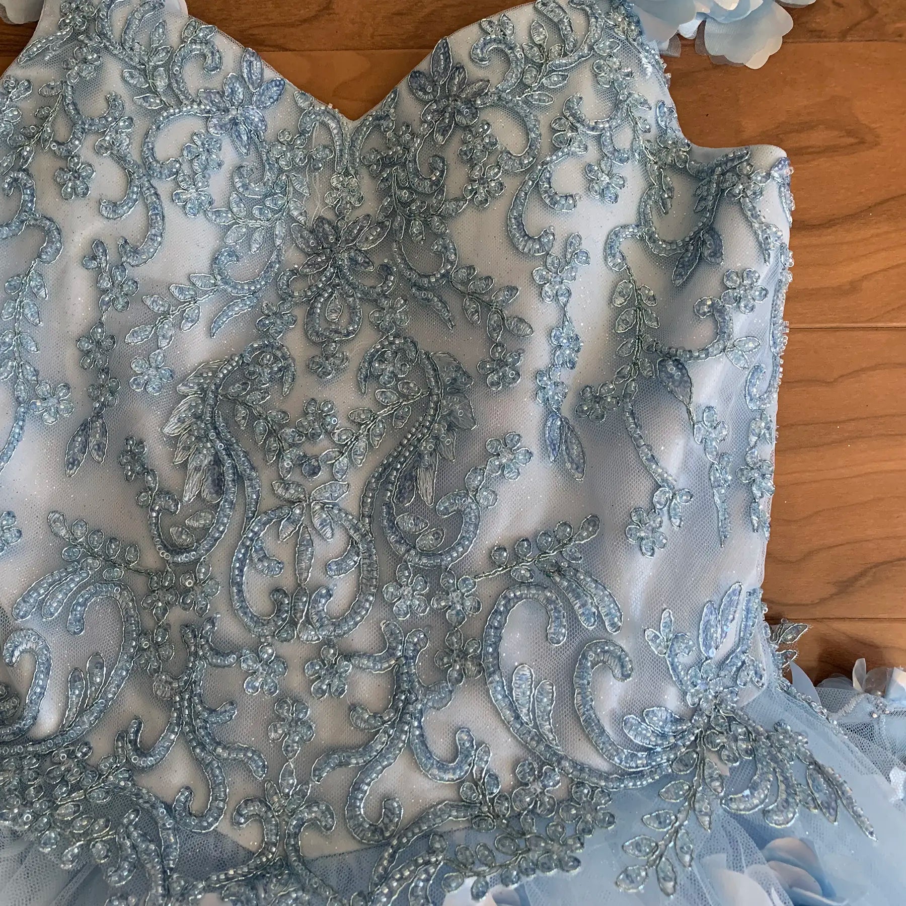 Front view of blue mini quince dress with 3D flowers stones pearls and detachable cape.