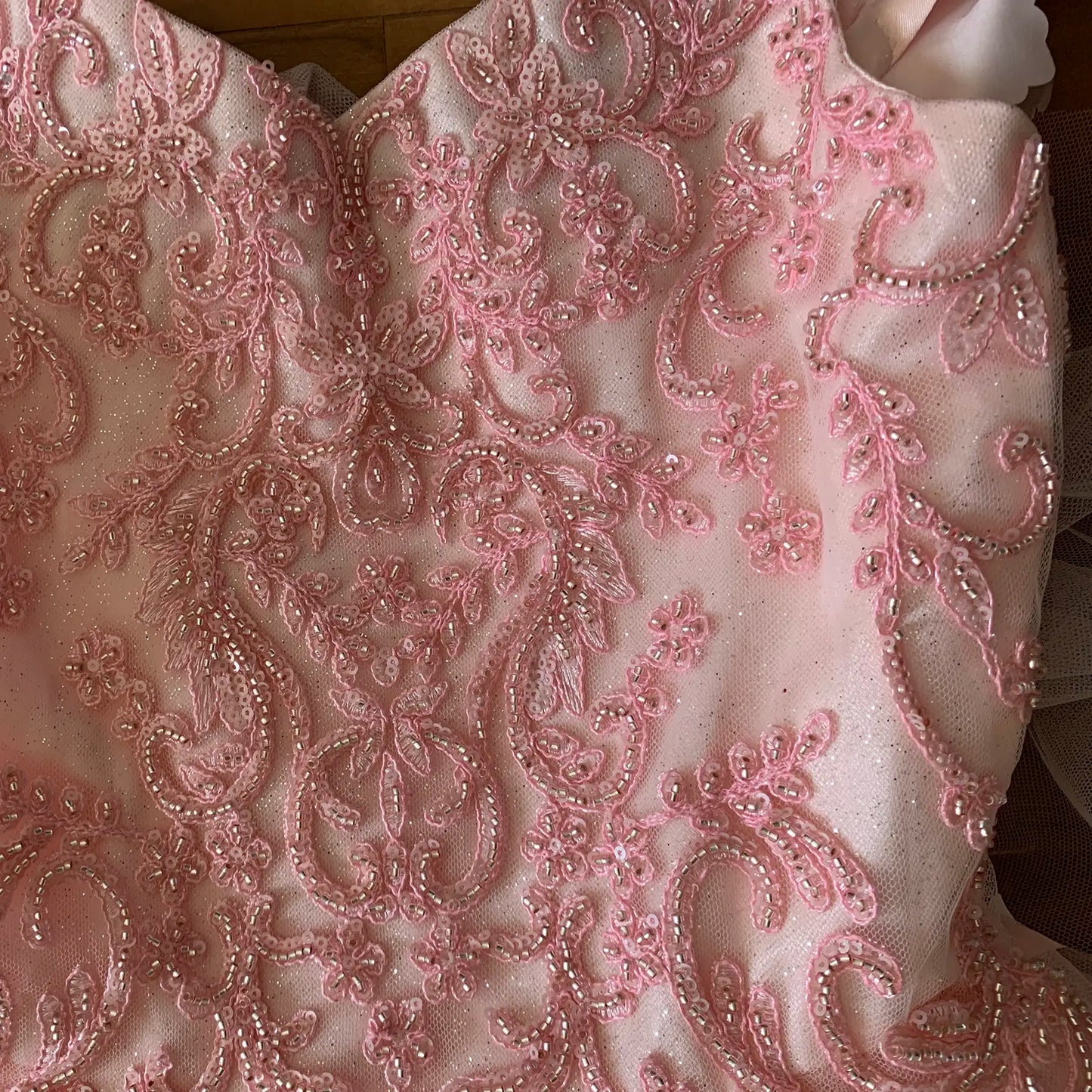 Blush Kids Dress with 3D Flowers, Stones, Pearls and Detachable Cape, Mini Quince Dress Close-up of pink embroidered fabric with intricate patterns