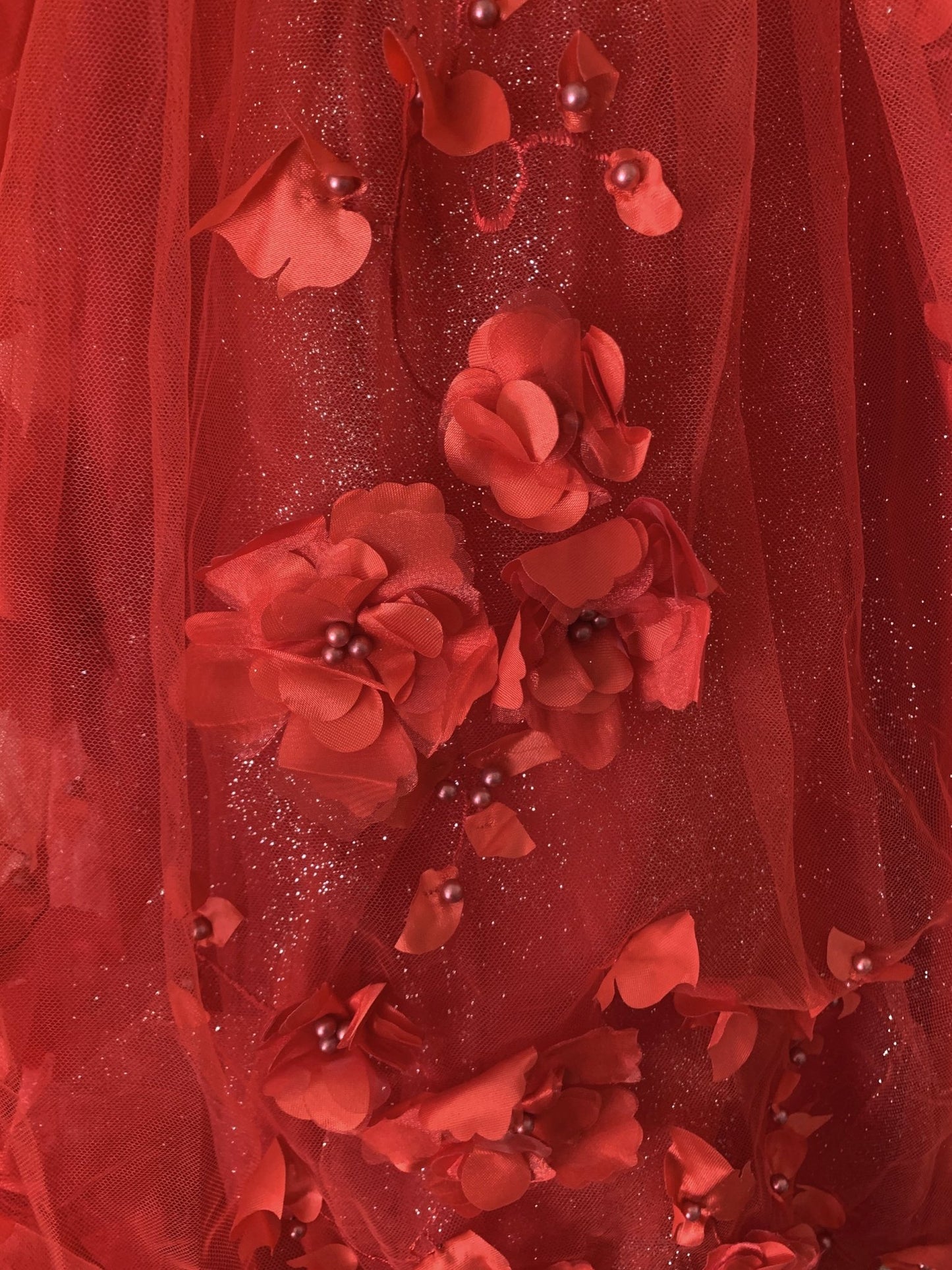 Red detail view kids mini quinceañera mini quince dress showing single 3D floral applique with pearl and stone accents.