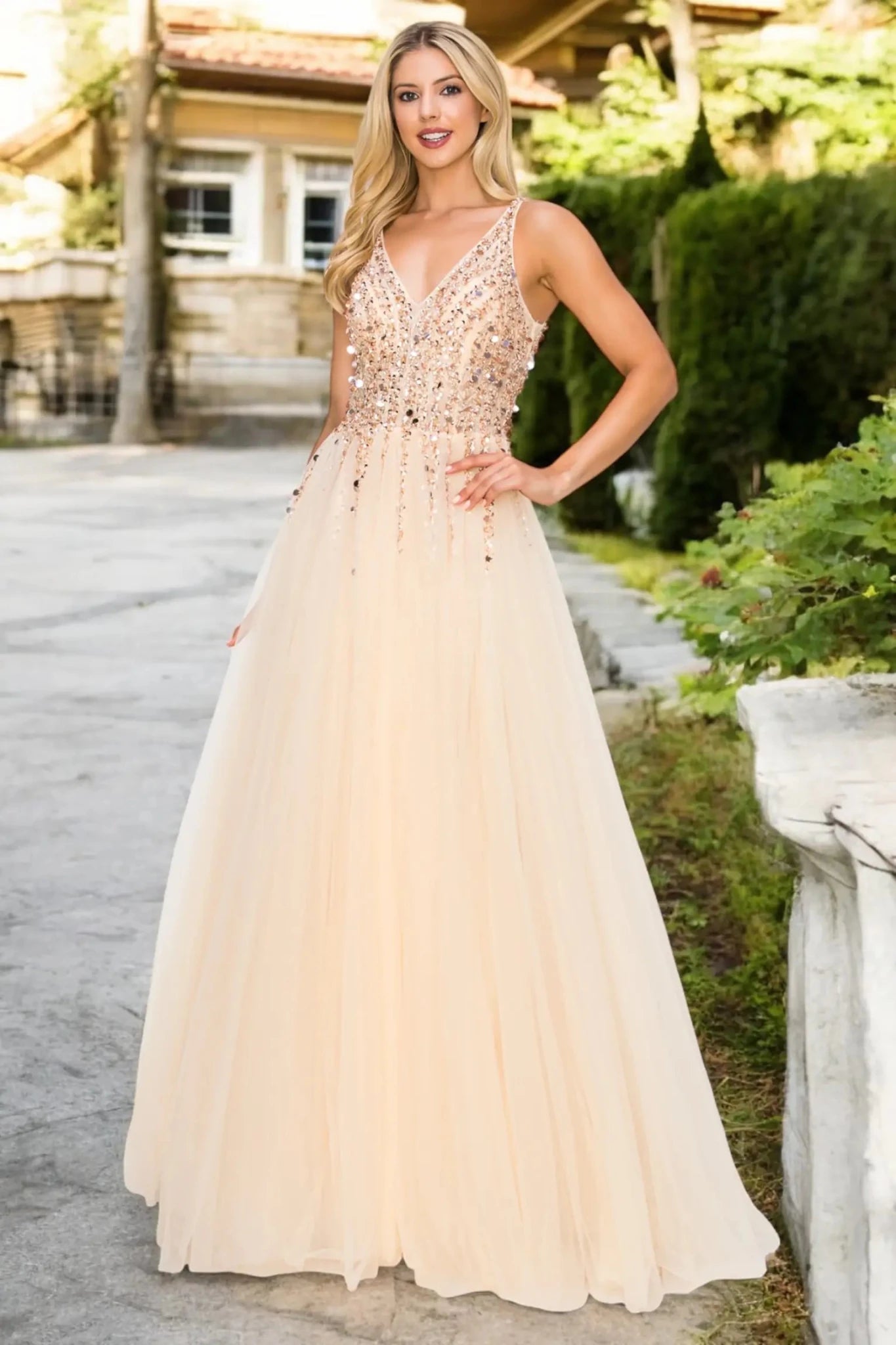 Full length- view of champagne formal dress with open V-length- and flowing skirt.