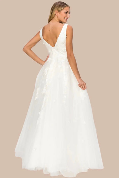 A full back view of a woman wearing a silver formal dress featuring a deep V-back and flowing skirt.