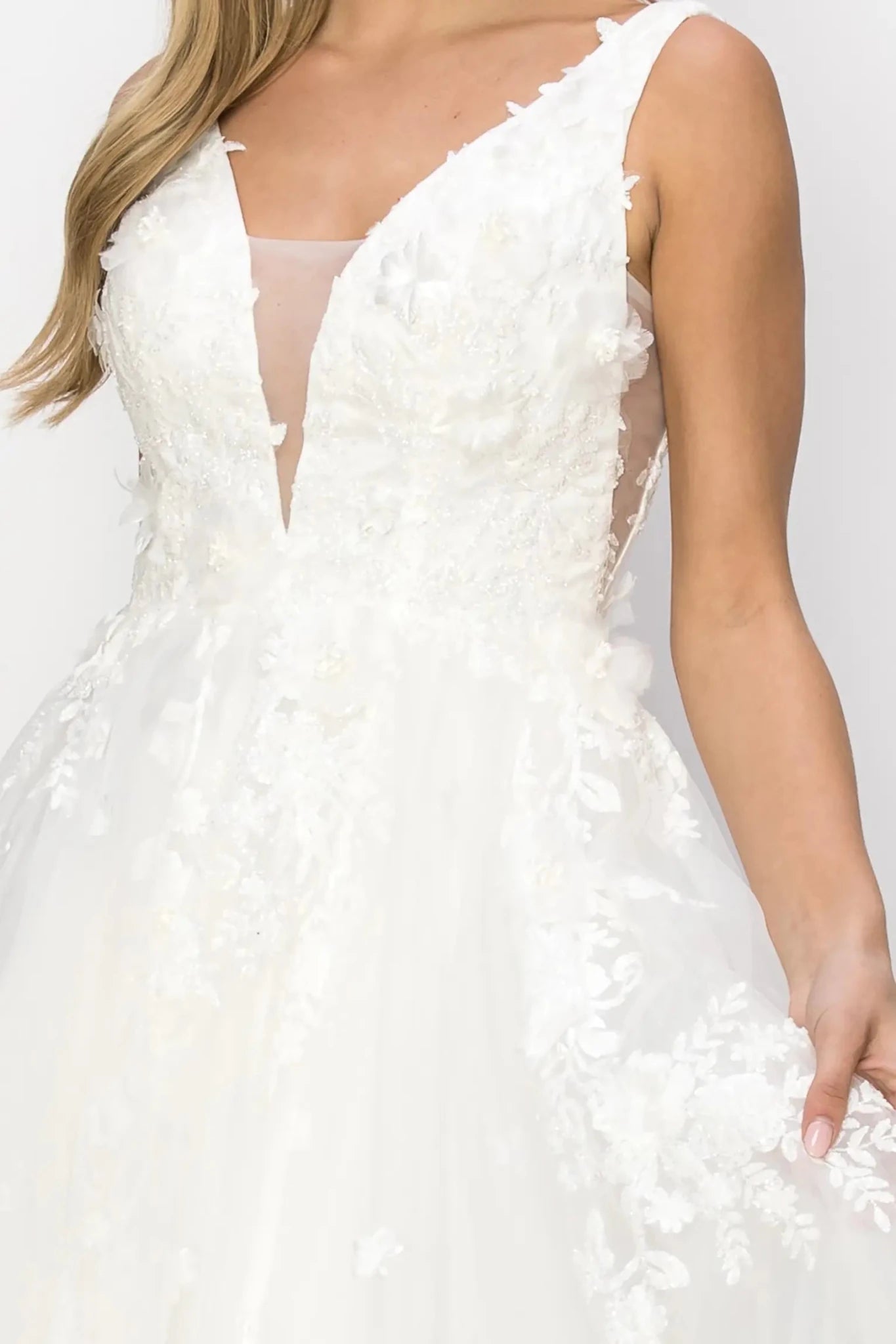 A close-up view of a woman wearing a silver lace bodice with pearl bead and organza flower detail.