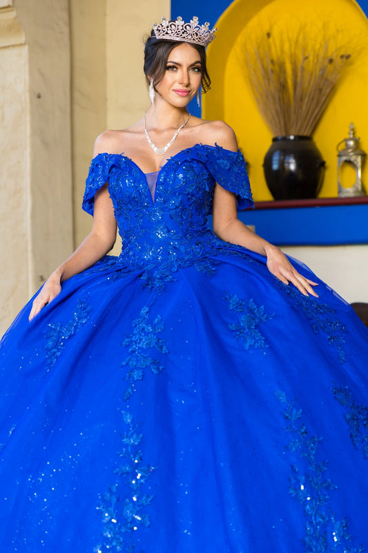 Shown in a upper-front view, the Royal Blue quinceañera dress has off-shoulder floral bodice and glitter skirt.
