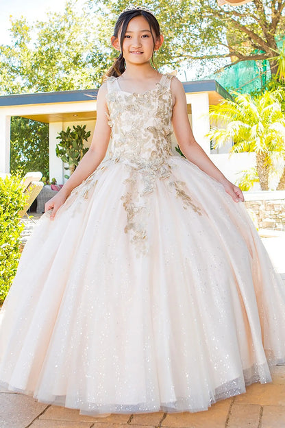 Girl standing front-facing in champagne mini quinceañera ball gown with glitter tulle fabric, metallic embroidered 3D butterflies, fitted bodice, and sparkling A-line skirt