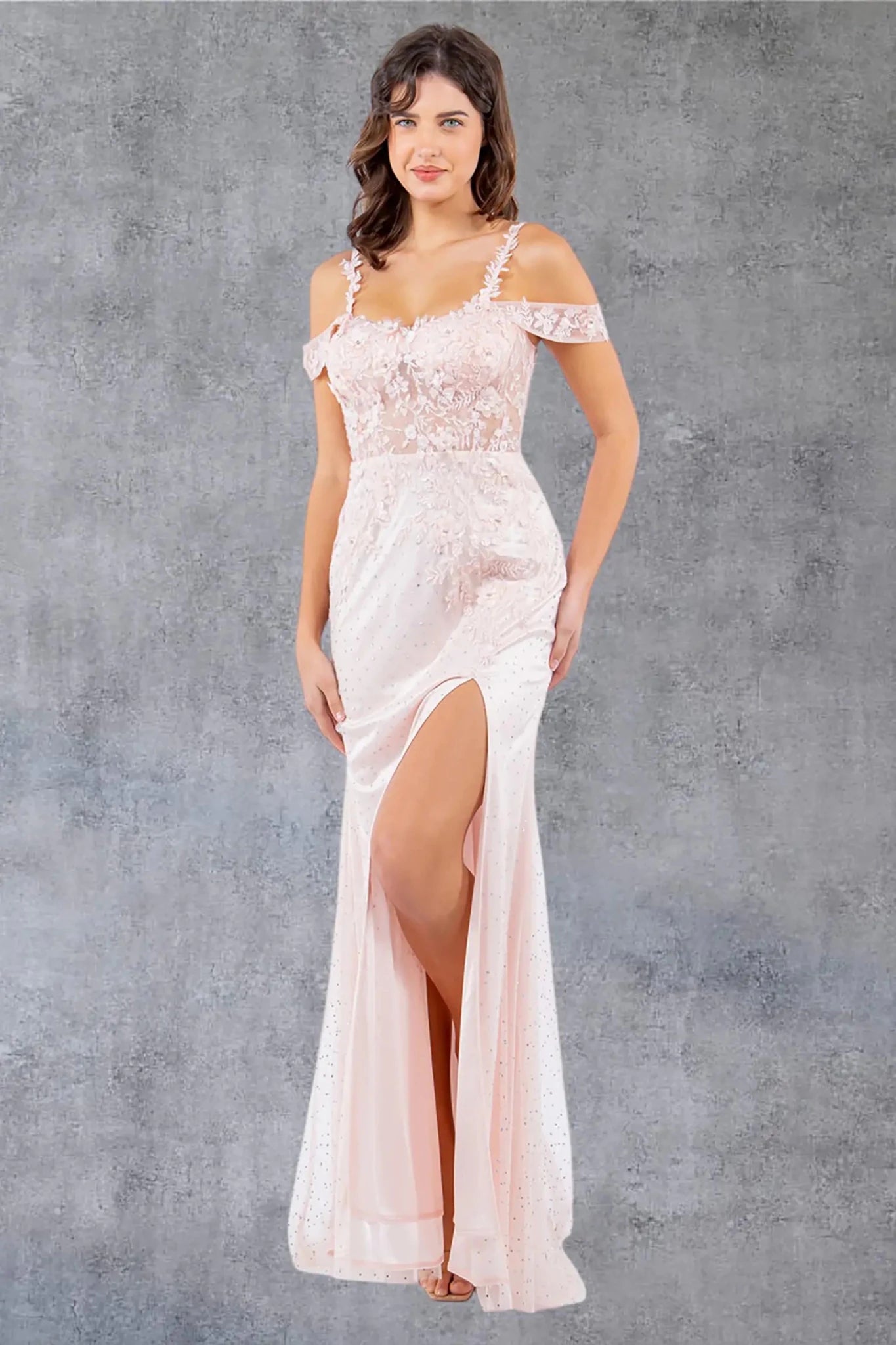 Full front view of a women wearing blush off-shoulder tulle prom dress with AB stones and 3D floral appliqués.