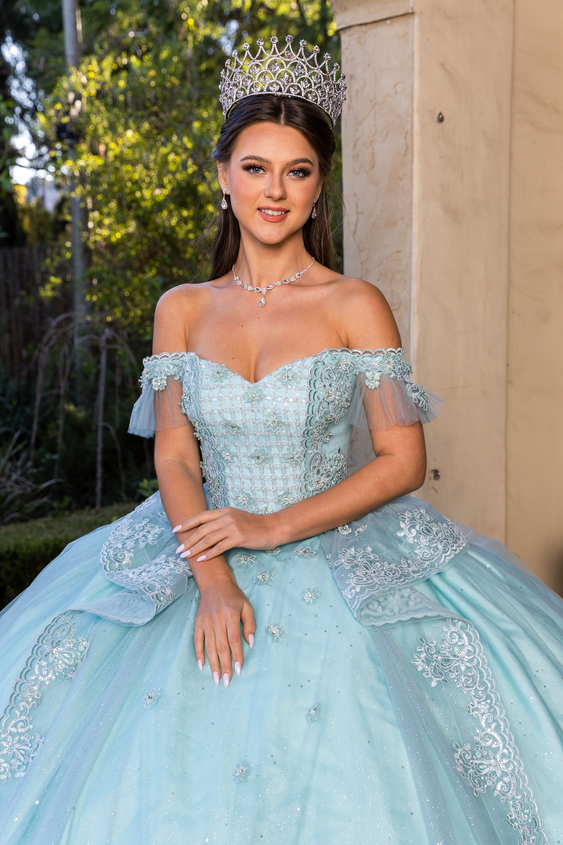 Aqua Blue Off-shoulder Beaded, Embroidered lace, Glitter tulle, Stone accents with a long tail ball gown - front view of woman wearing dress and crown