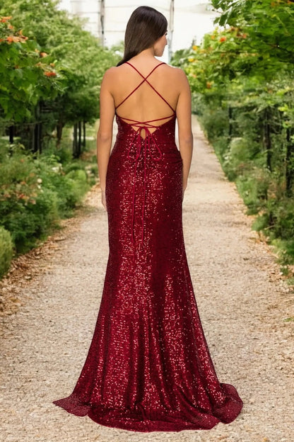 A full-length view of a woman wearing burgundy formal prom dress with lace-up corset closure.
