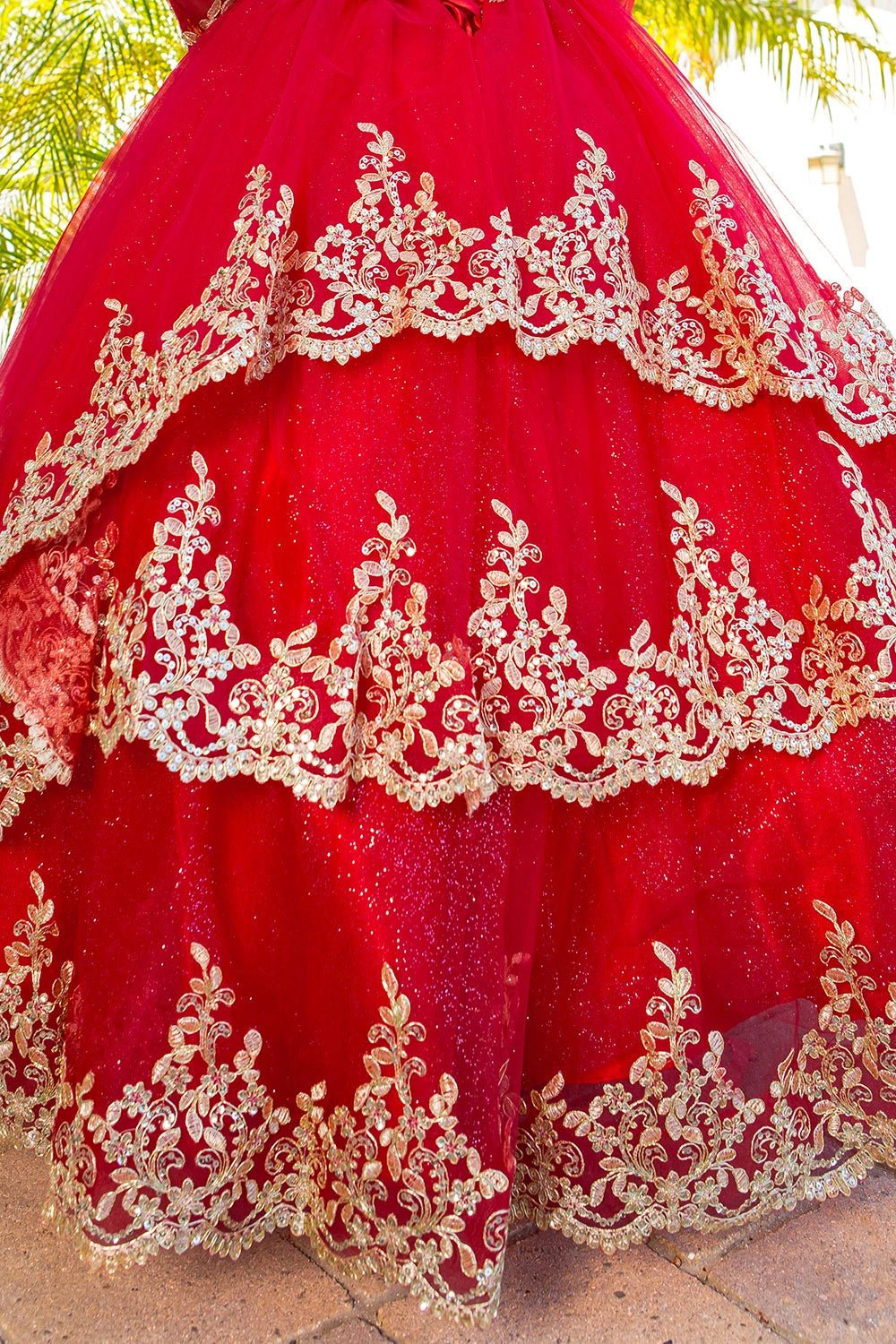 Presented in a skirt detail, the Red mini quince dress has tiered glitter tulle skirt edged with gold lace.