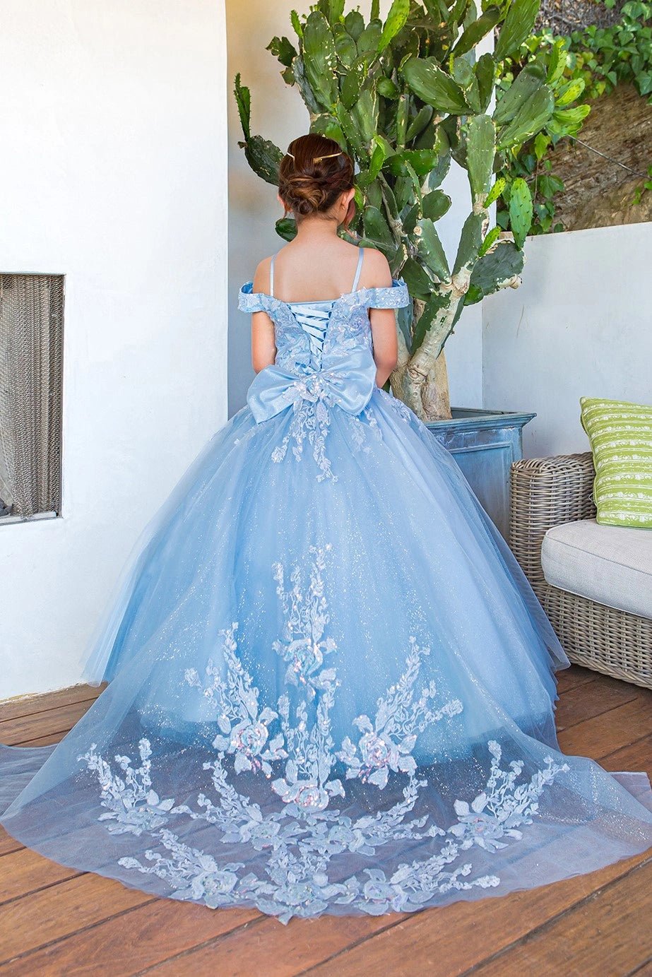 Shown in a back view, the Blue mini quince dress has lace-up back, bow and white floral lace train.
