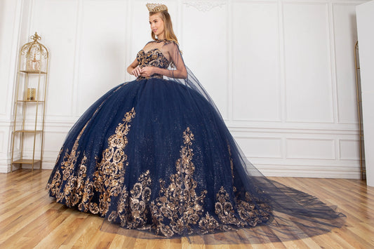 Displayed in a front view, the Navy quinceañera dress has gold lace embroidery over the full ball skirt and sheer cape.