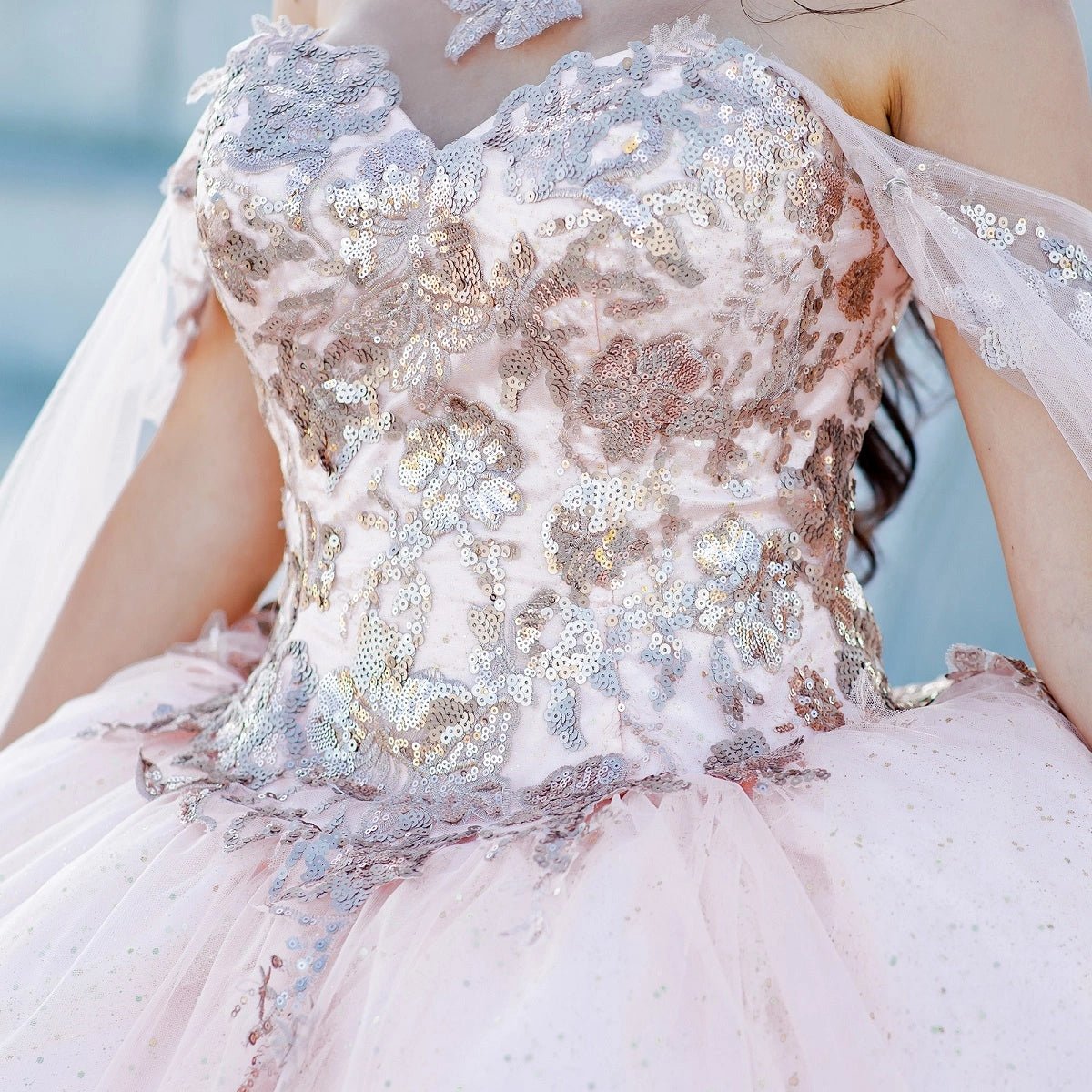 Viewed in a bodice detail, the Blush quinceañera dress has sweetheart bodice covered with gold floral lace.