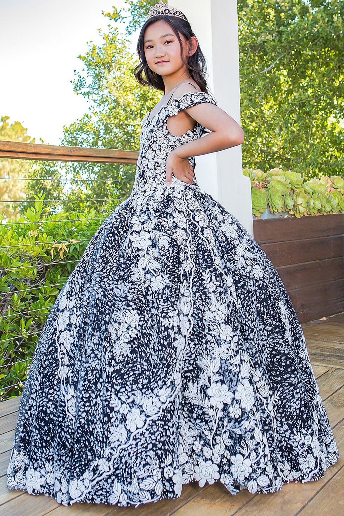 Black white side view kids mini quinceañera mini quince dress with off-shoulder tulle, glitter fabric and 3D floral applique.