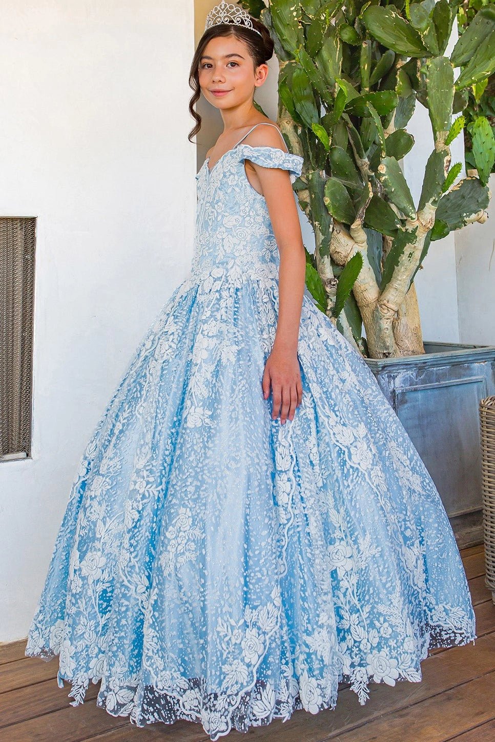 Shown in a angled view, the Blue mini quince dress has off-shoulder floral lace and a scalloped skirt hem.