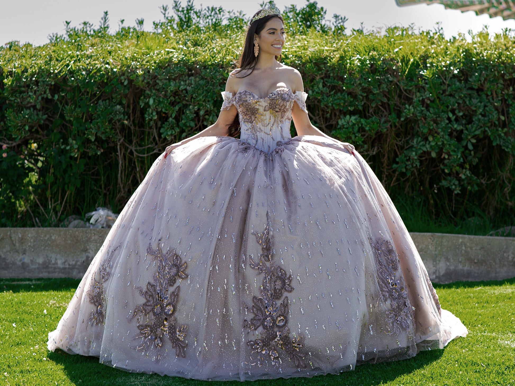 Quinceanera | Mauve Bead-Embroidered & Sequin Appliques Bodice Off-shoulder w/ Multiple Glitter Tulle Ballgown with Train - front view of woman wearing dress smiling off into the distance