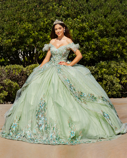 Girl in a sage green floral quince dress standing outdoors with greenery in the background