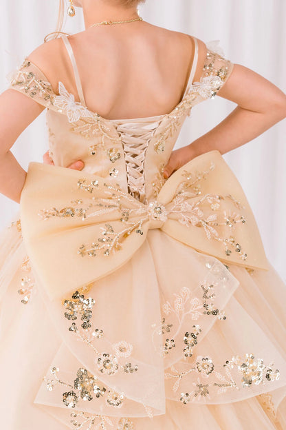 Champagne front view kids mini quinceañera ball gown with floral lace, bow detail and glitter tulle skirt
