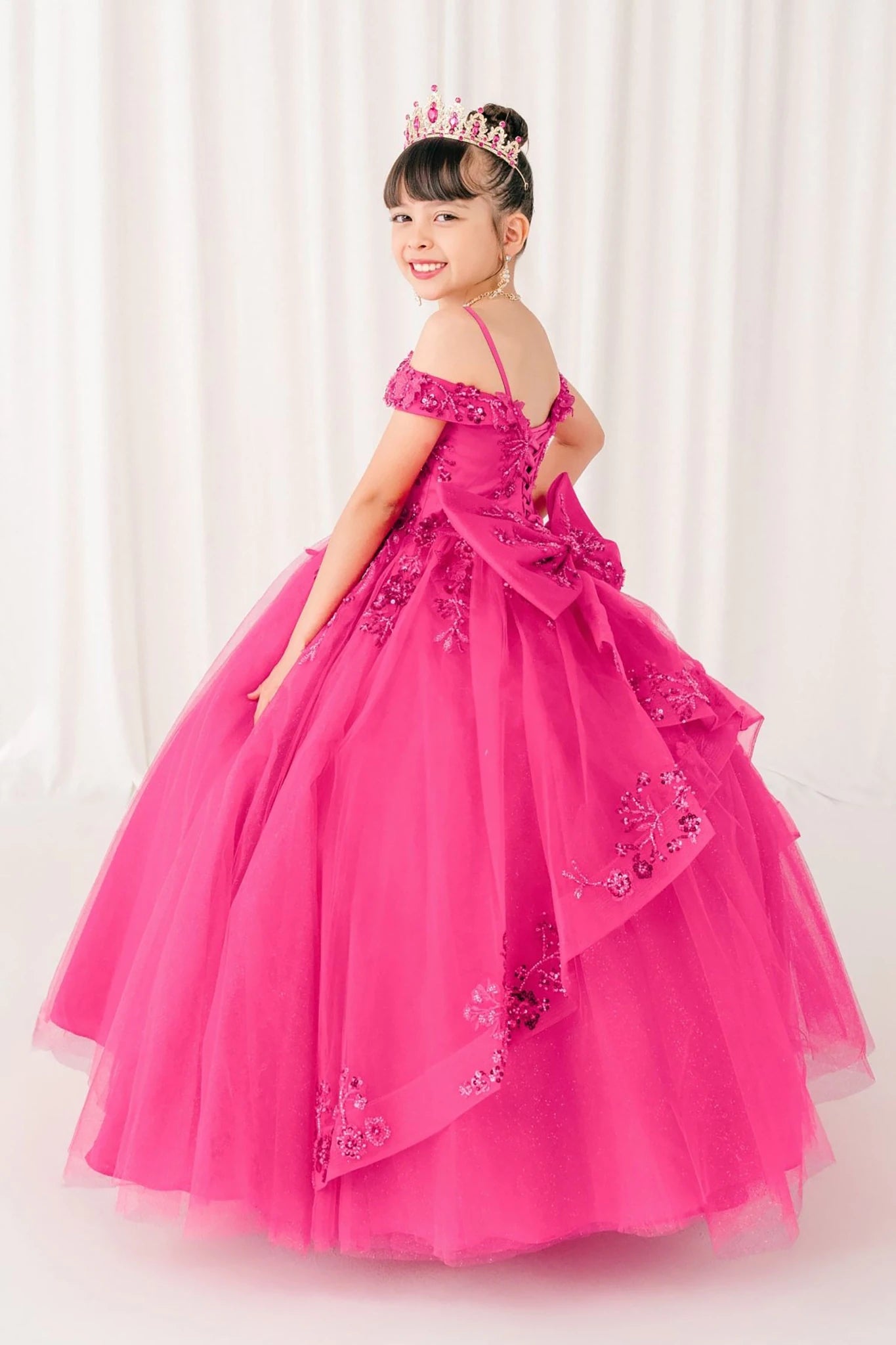Fuchsia front view kids mini quinceañera ball gown with bead embroidery, tiara and glitter tulle sweep train