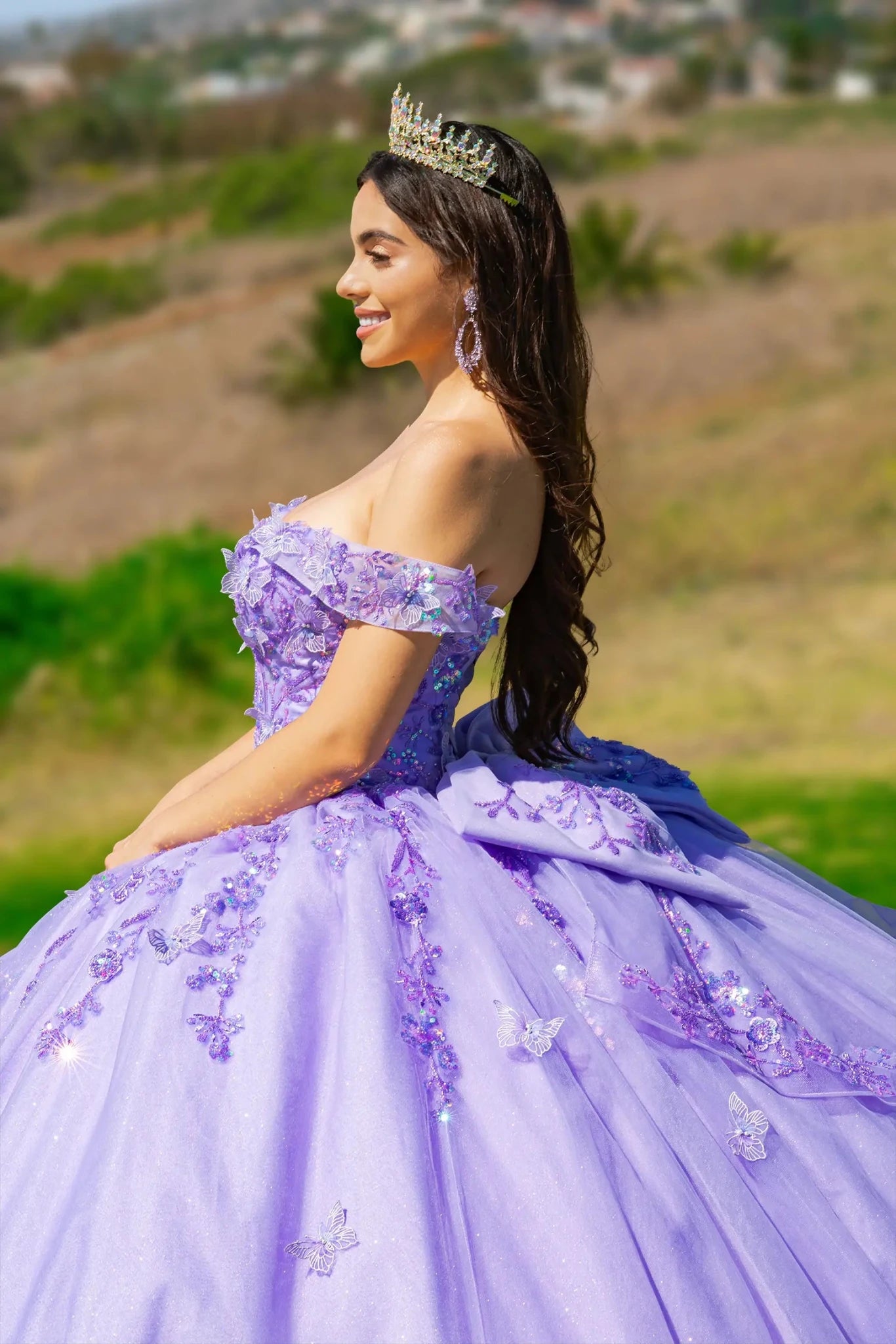 A girl wearing a lilac quince dress is shown in profile, with dense 3D embroidery also covering the off-the-shoulder detail.