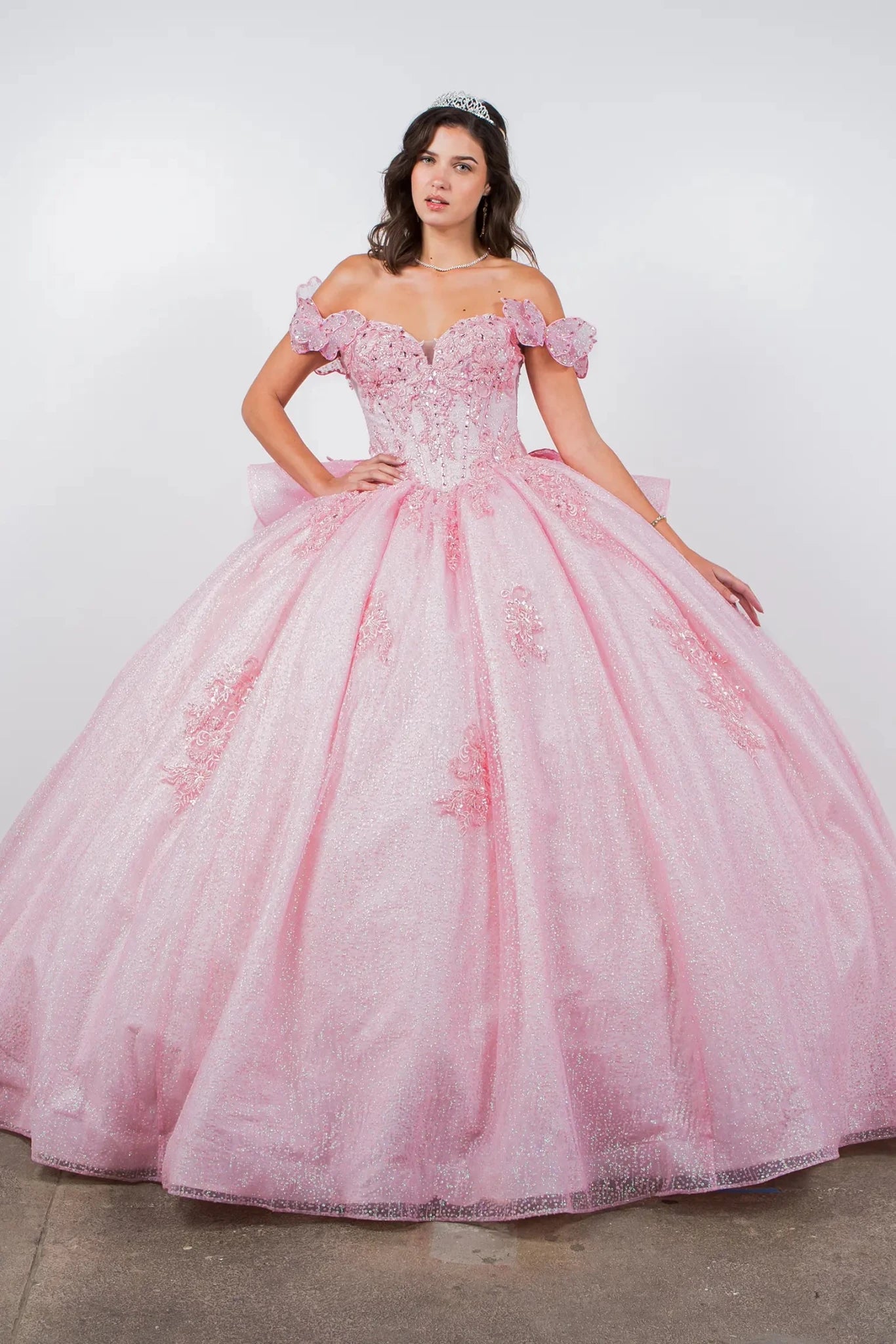 a girl wearing a Blush Off-Shoulder Beaded Bodice with Crafted Lace Butterfly and Floral Appliqué Sweet 15 Ballgown