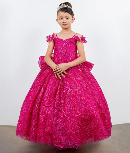 Young girl wearing a pink sparkly dress against a white background