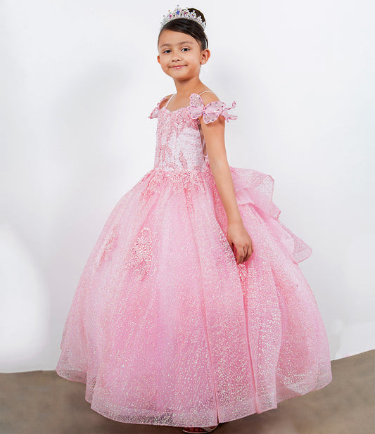 Young girl in a pink formal dress with a tiara against a white background