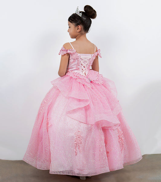 Young girl in a pink formal dress with a tiara against a white background