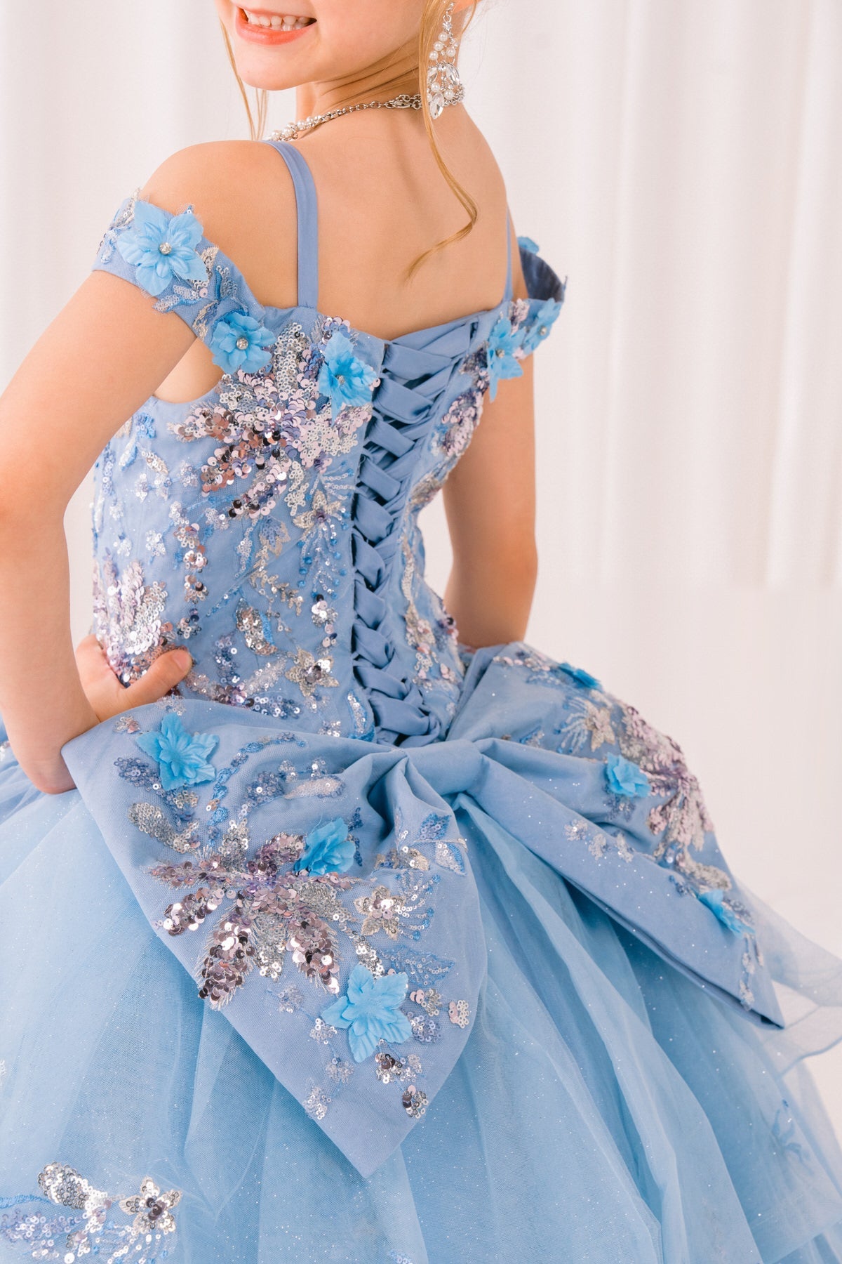Blue front view kids mini quinceañera mini quince dress with floral lace, sequin details and lace back up.