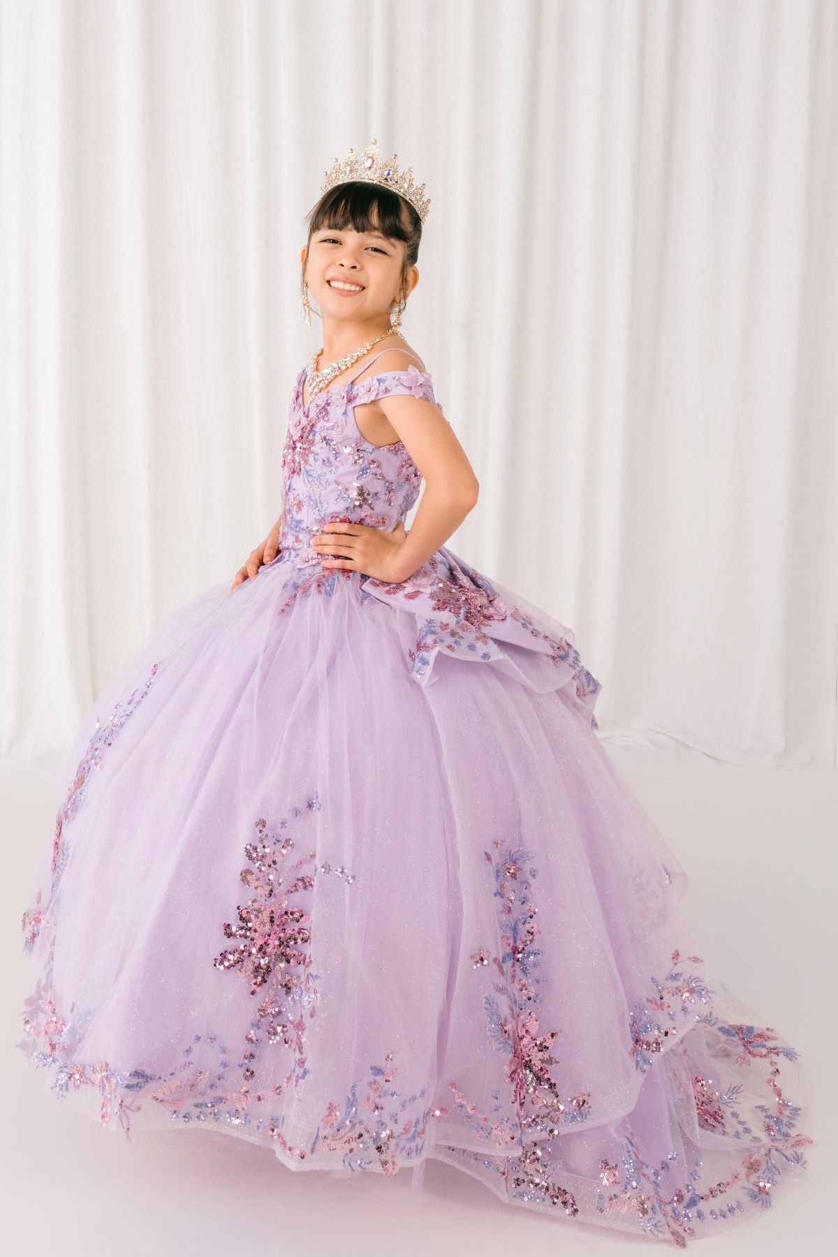 Lilac front view kids mini quinceañera mini quince dress with off-shoulder 3D beaded floral applique and glitter tulle train.