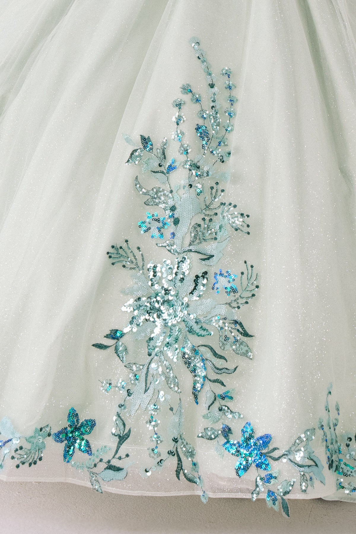 Sage fabric close-up kids mini quinceañera mini quince dress with floral lace embroidery and glitter tulle fabric.