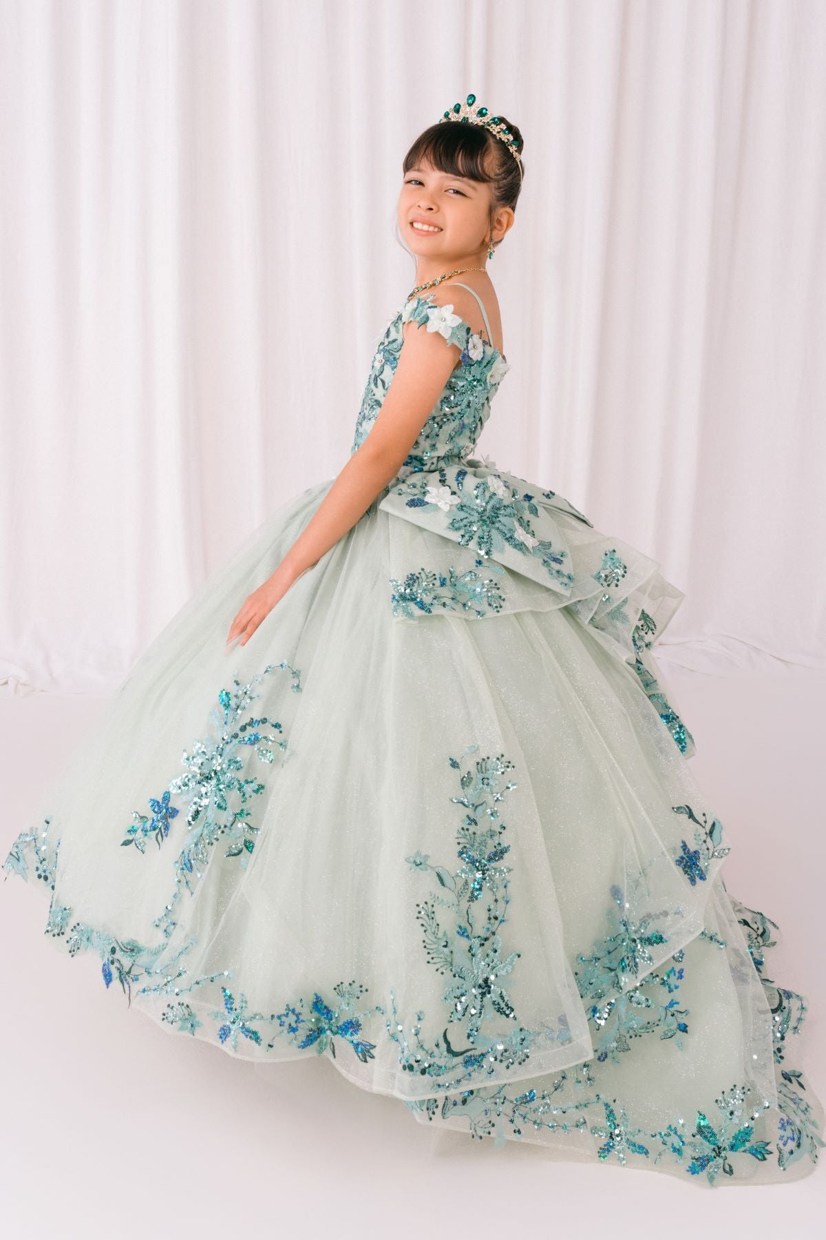 Sage front view kids mini quinceañera mini quince dress with floral lace, sequin details and glitter tulle train.